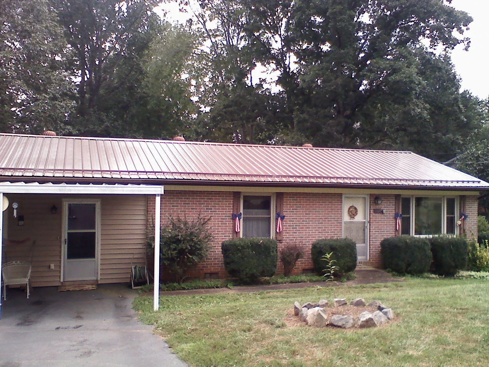 Bronze metal roof and carport on a brick ranch home — Roof Repair work by our crew in Branchport